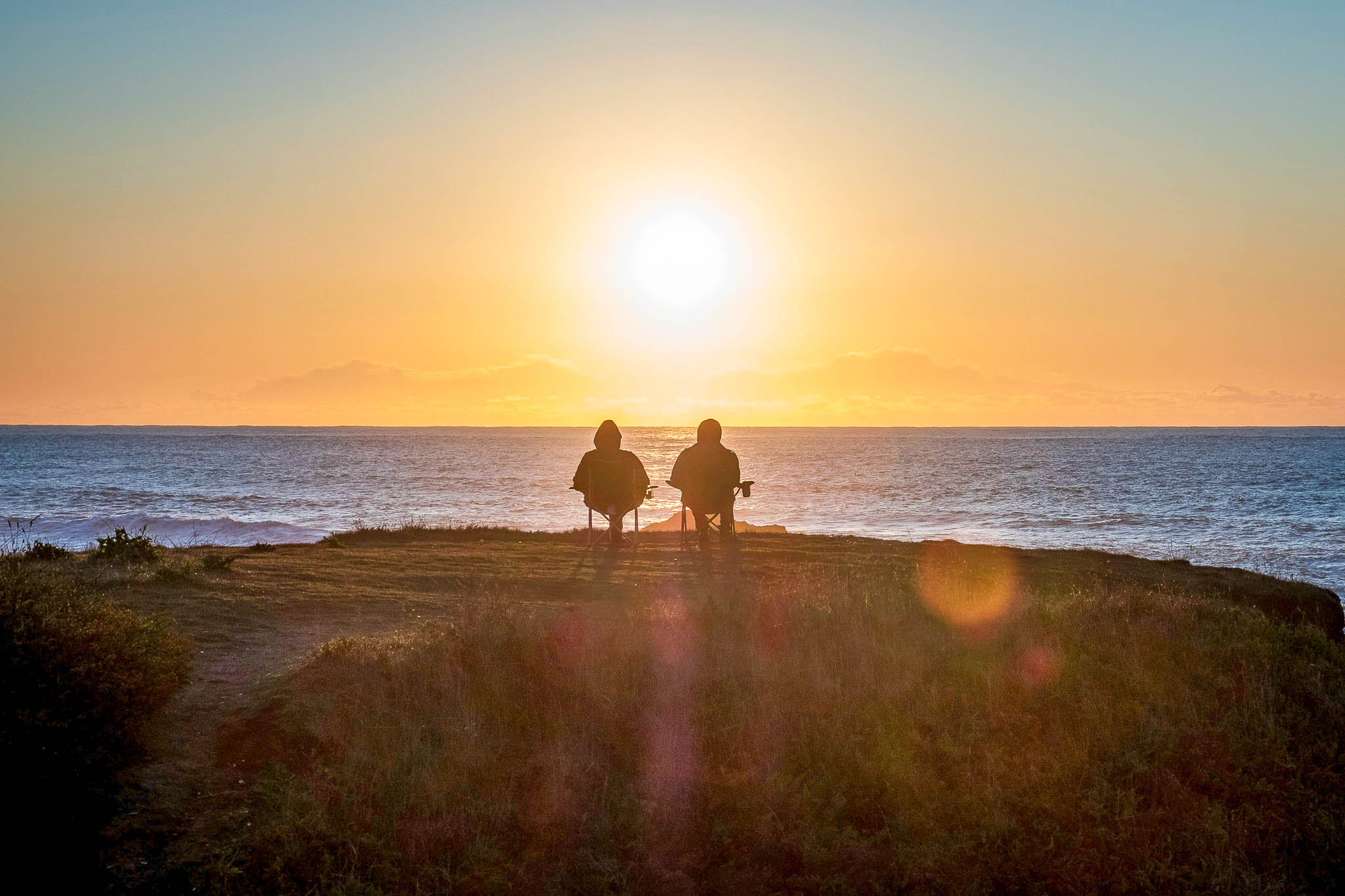 Cyclists overlooking lake at sunset