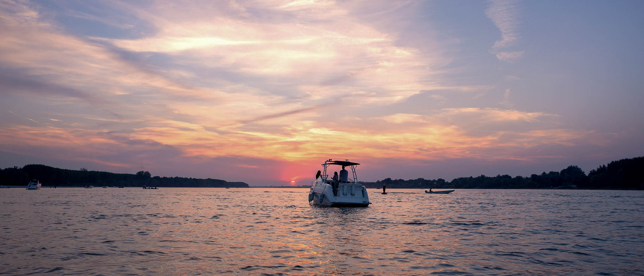 Boat on water at colorful sunset