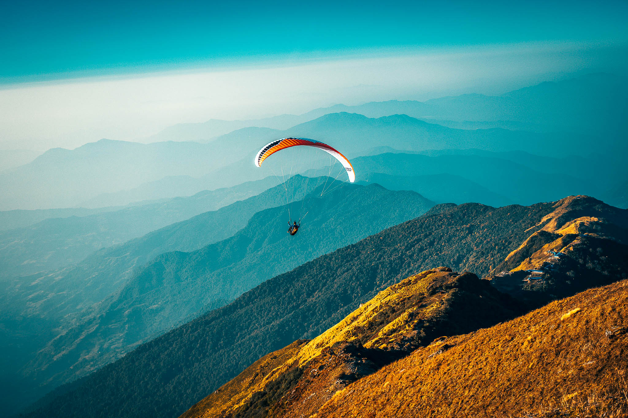 Paraglider soaring over mountain peaks